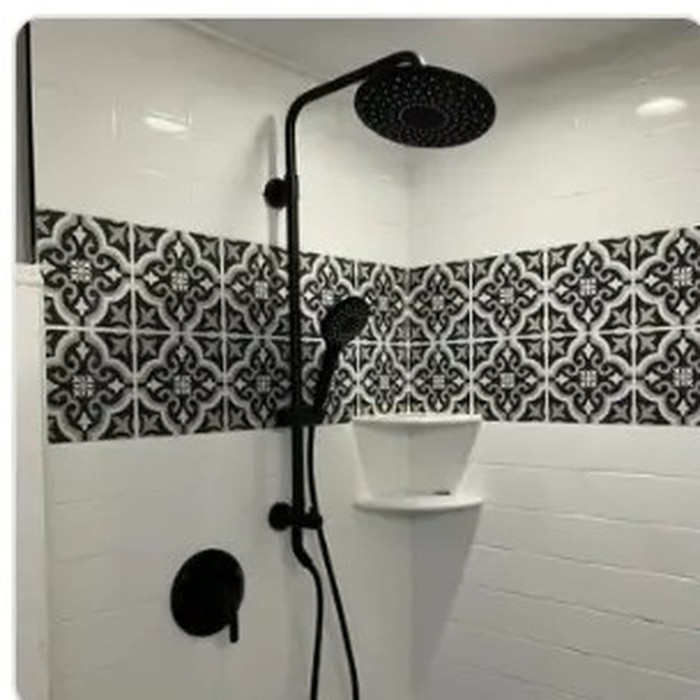 Finished shower with matte black fixtures and patterned tile band