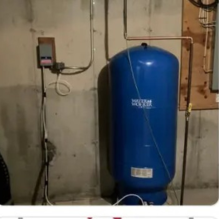 Blue pressure tank and copper piping installed in a basement